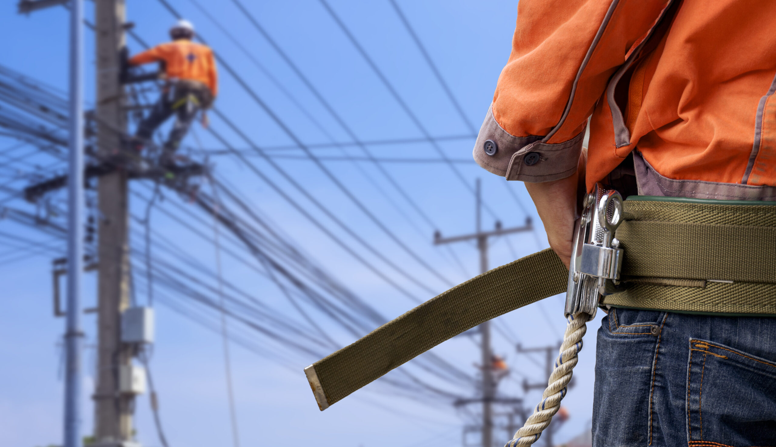 electrician-wearing-safety-belt-with-blur-background-electrical-workers-are-working-power-pole